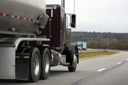 Maroon 18-wheeler truck driving past