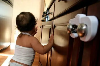 Fourth Child Death Linked to IKEA Dresser Recall 1 Baby resting on childproofed wooden kitchen cabinets