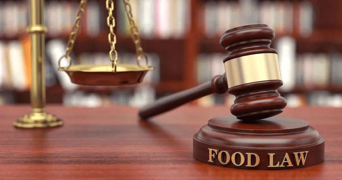 Blog 15 Gavel with "Food Law" embedded on it and gold scales on desk