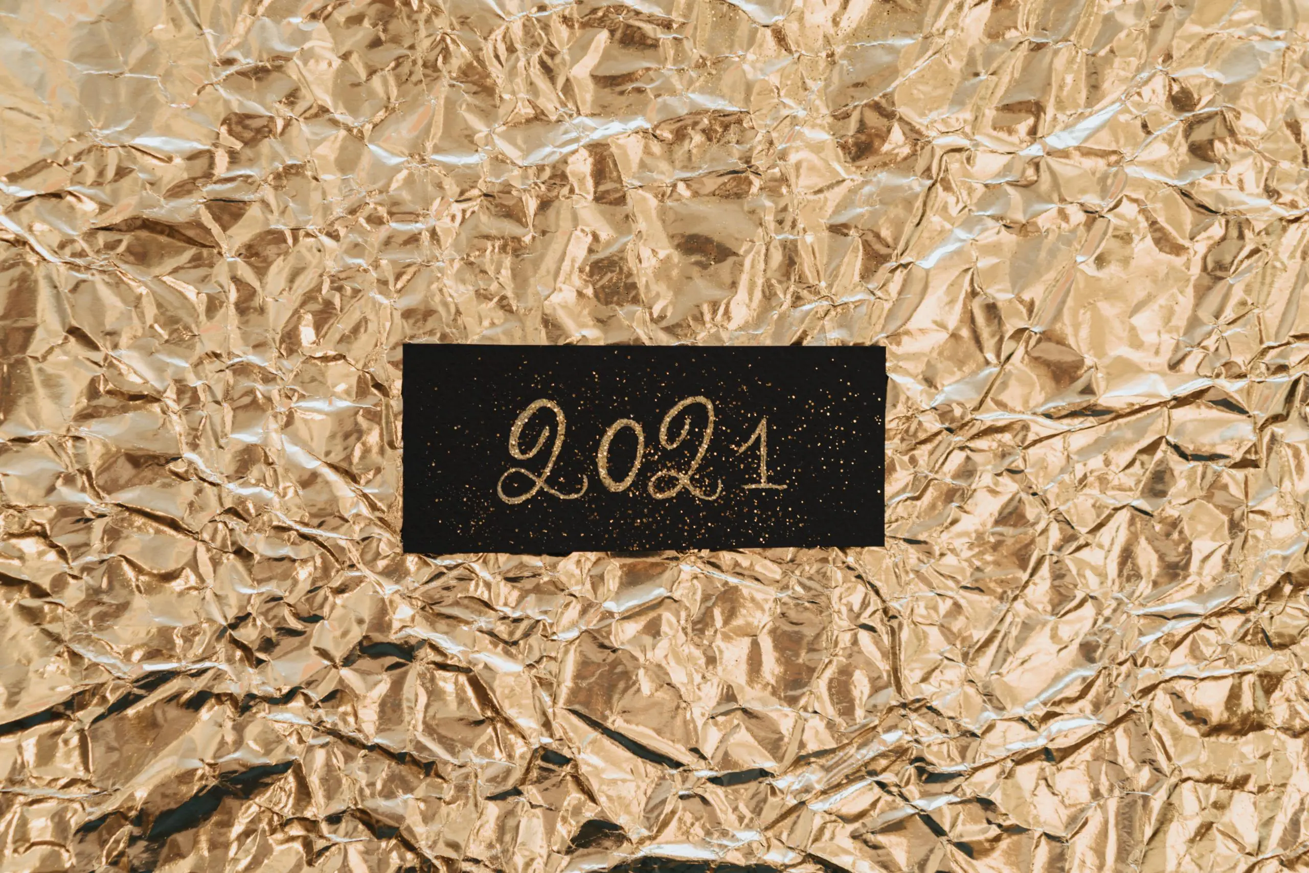 Blog 3 Crumpled gold paper with '2021' written on black label.
