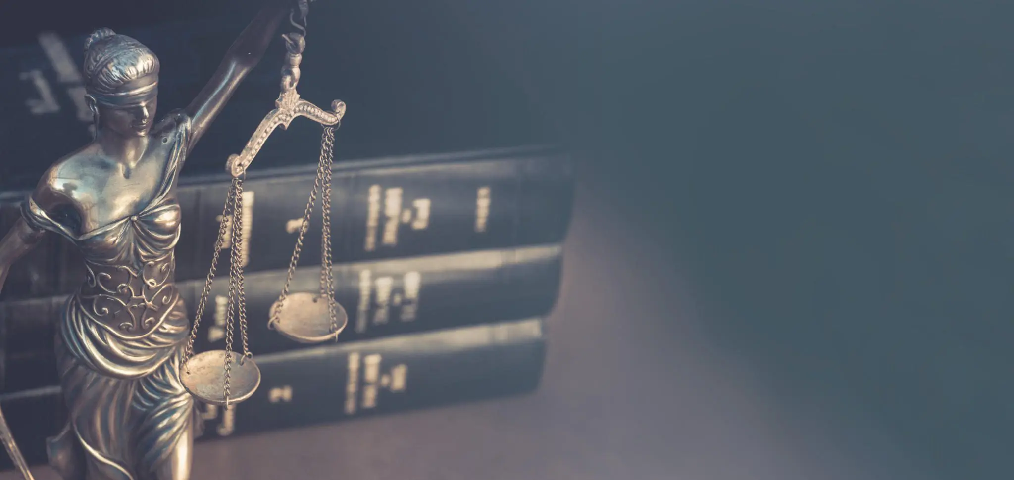 Justice scales with law books in the background for legal cases.