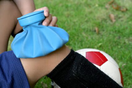 Applying ice to a child's knee injury