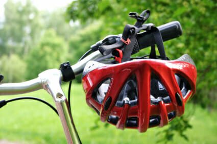 Red helmet hanging off a bicycle handle