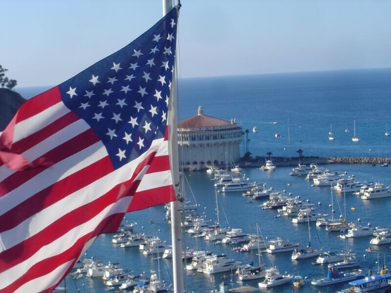 American flag over port with numerous docked boats