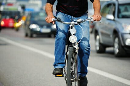 man riding bicycle alongside road