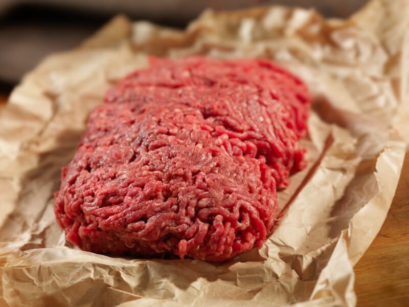 Ground beef patty sitting on wrapping paper