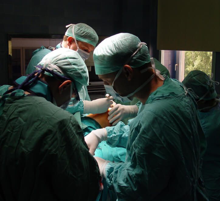 Several surgeons operating on a patient in the operating room.