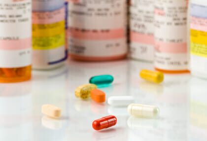 Prescription medication bottles with multiple pills of various colors