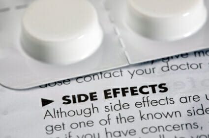 Side effects leaflet with a tablet container sitting on top