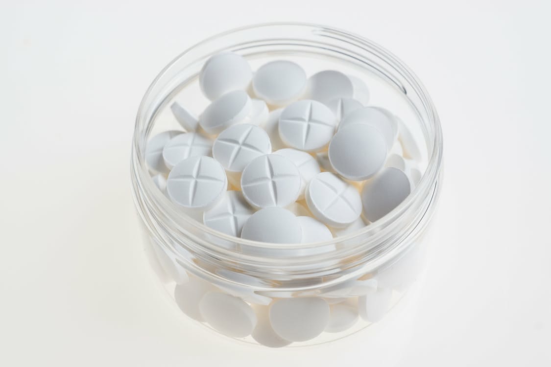 White tablets in glass container