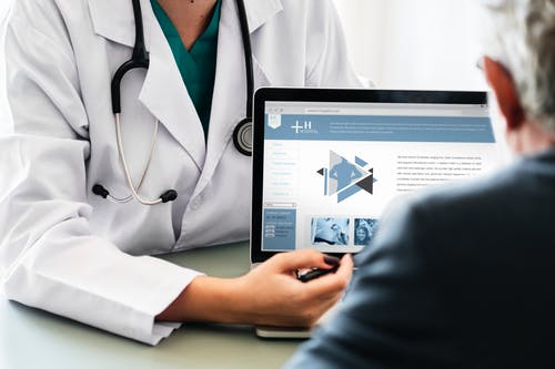 Doctor reviewing information on tablet to patient