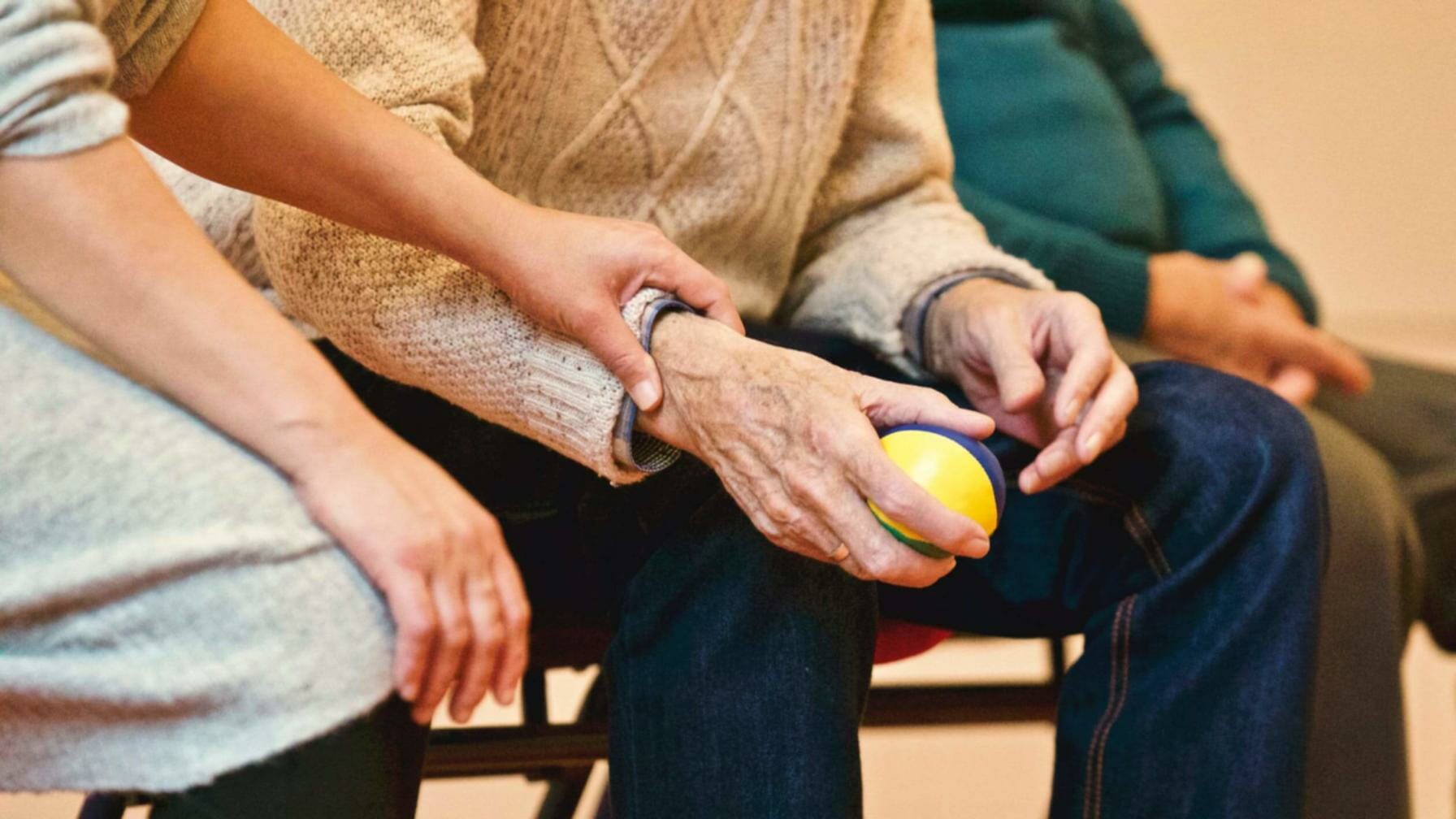 Elderly patient holding a stress ball in being comforted