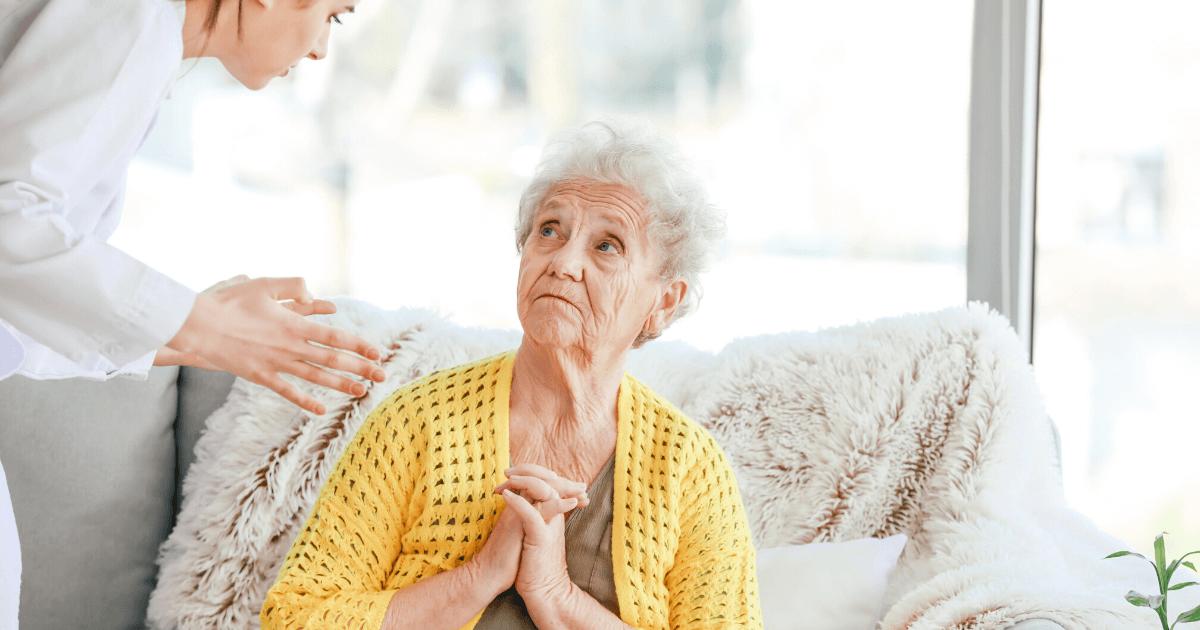 Elderly woman looking worried talking to her nurse