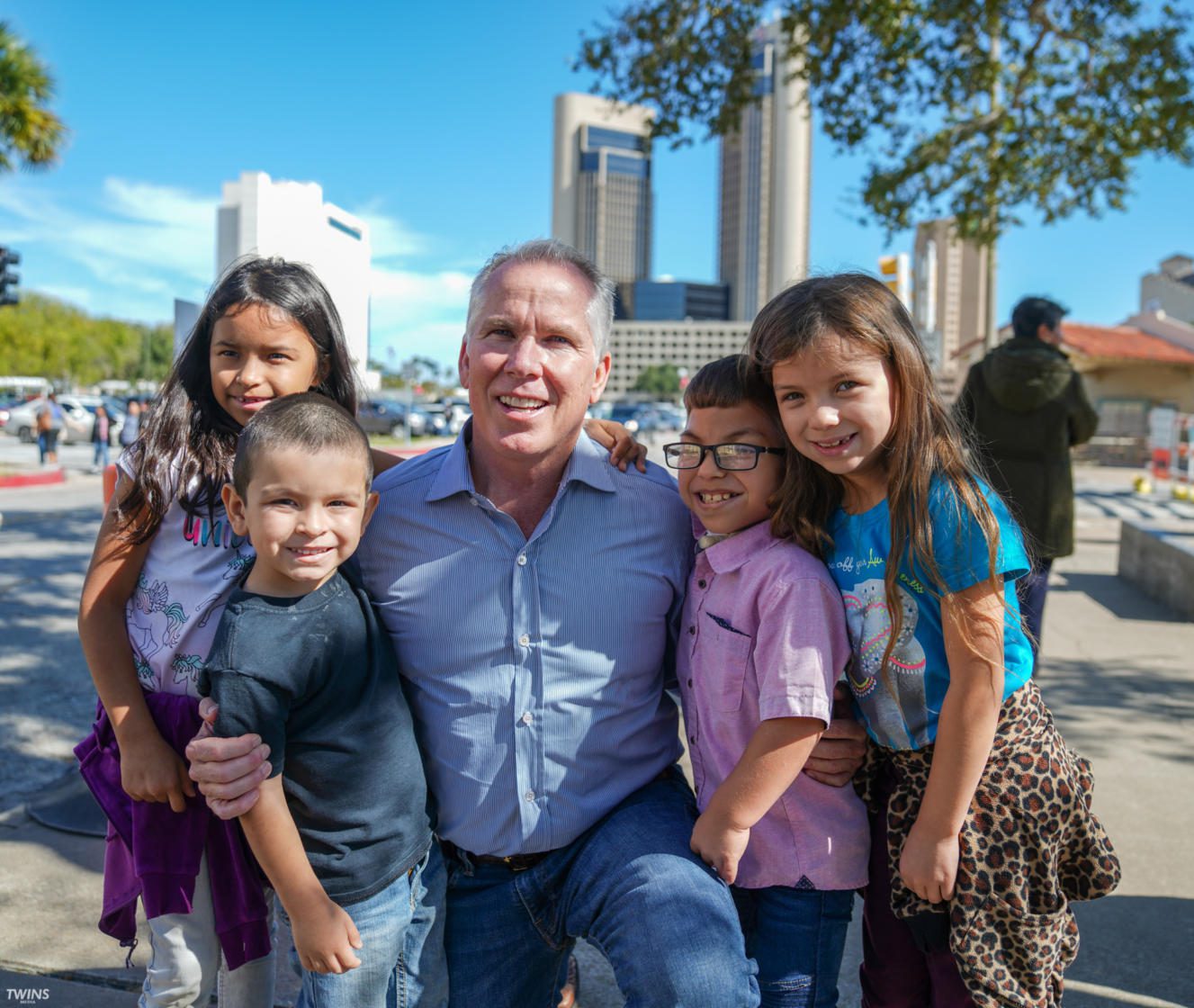 Thomas J. Henry posing with children during 2019 Turkey Giveaway
