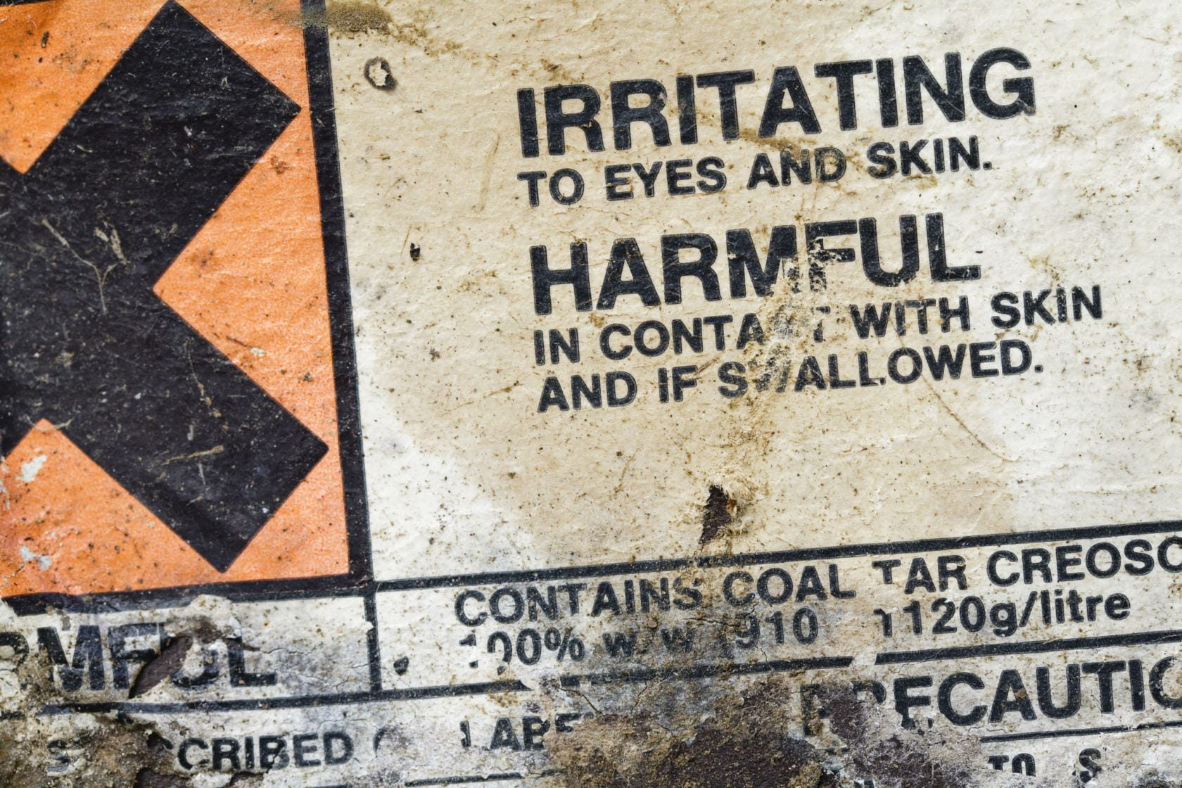 Warning label on a container of creosote indicating it to be harmful and a chemical irritant.