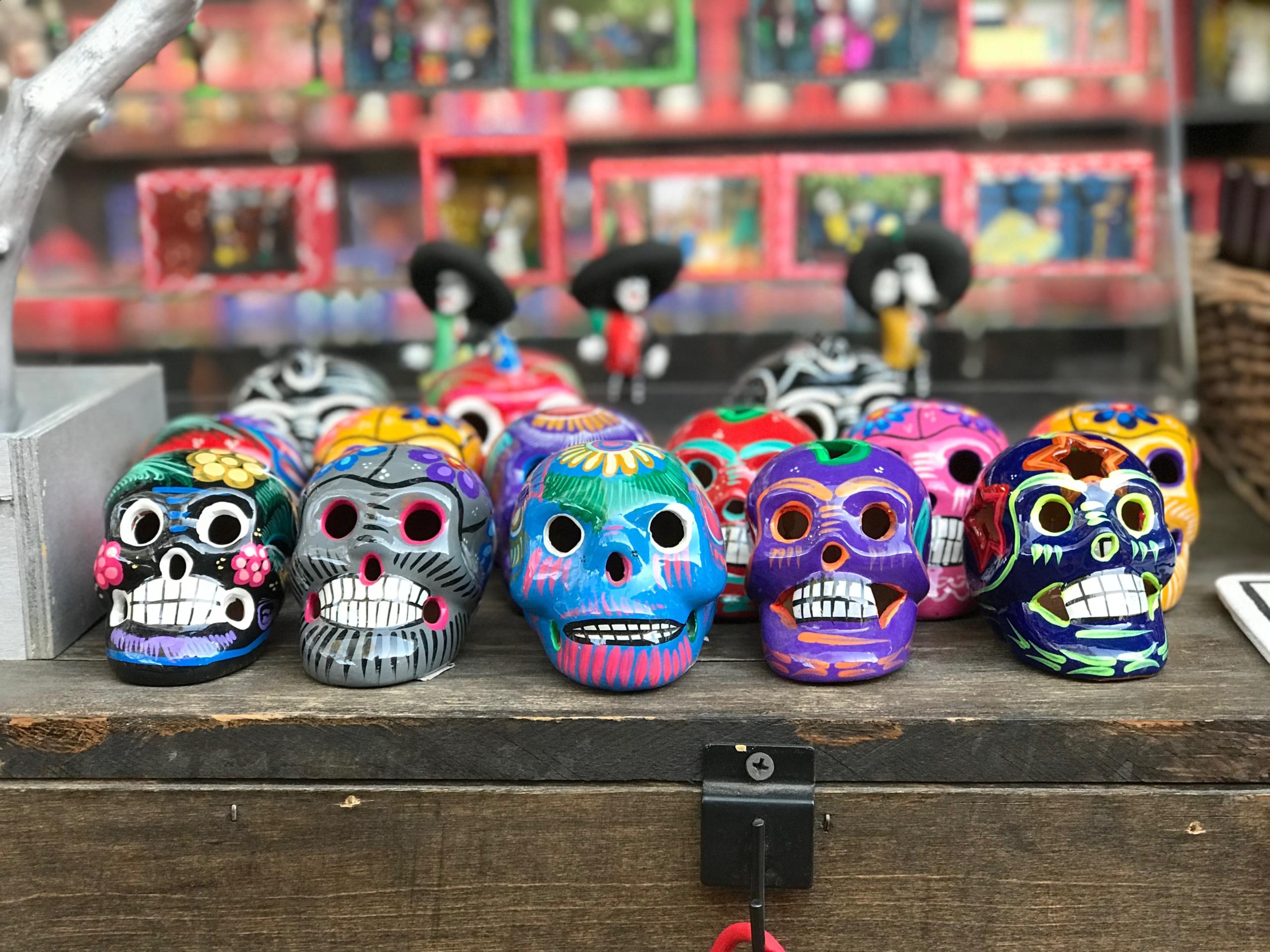 Colorful decorative skulls displayed on a wooden table
